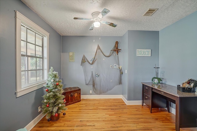 bathroom featuring ceiling fan, wood-type flooring, and a textured ceiling