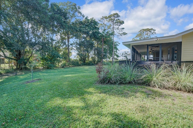 view of yard with a sunroom and ceiling fan