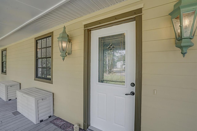 view of exterior entry featuring covered porch