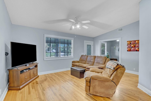 living room with ceiling fan, light wood-type flooring, and vaulted ceiling