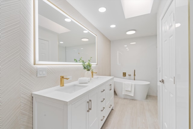 bathroom with a tub and vanity