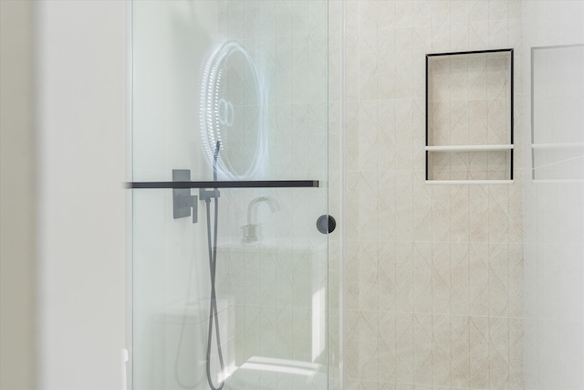 bathroom featuring a shower with shower door