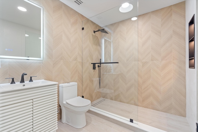 bathroom featuring vanity, toilet, and tiled shower