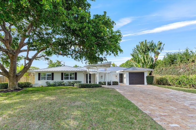 single story home featuring a garage and a front yard