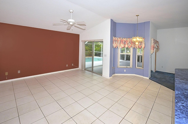 empty room featuring lofted ceiling, light tile patterned floors, and ceiling fan with notable chandelier