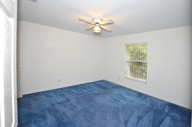 spare room with ceiling fan and dark carpet