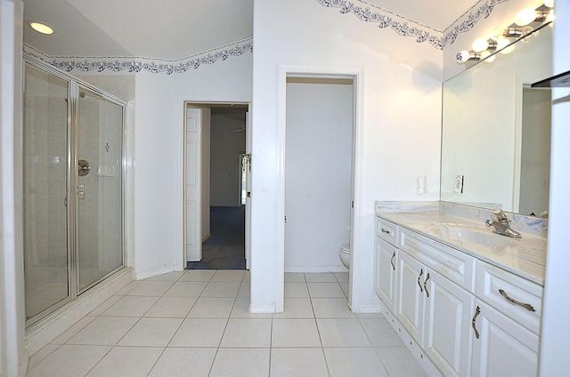 bathroom featuring tile patterned flooring, vanity, a shower with shower door, and toilet