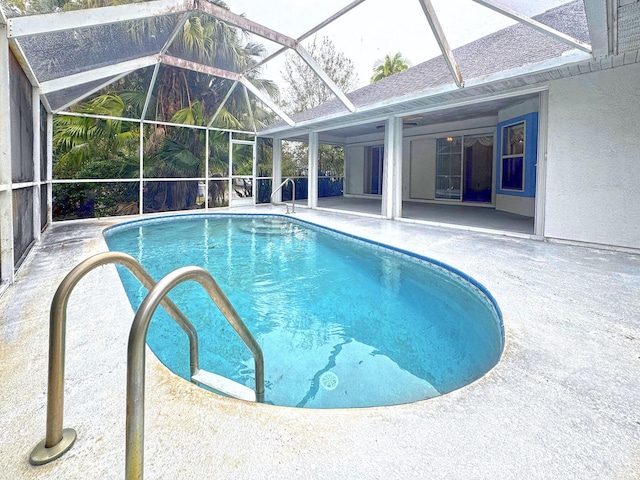 view of pool featuring glass enclosure and a patio area