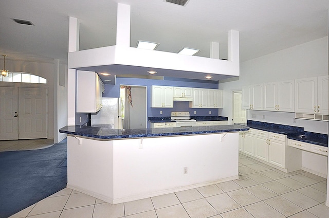 kitchen featuring white cabinetry, kitchen peninsula, white appliances, a breakfast bar area, and light tile patterned flooring