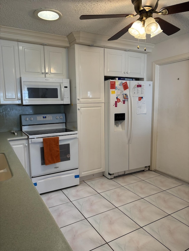 kitchen with a textured ceiling, white cabinets, light tile patterned flooring, and white appliances