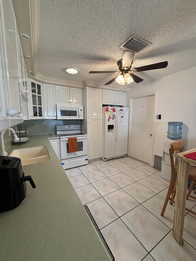 kitchen featuring white appliances, ceiling fan, sink, white cabinets, and light tile patterned flooring