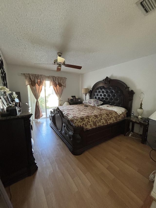 bedroom with a textured ceiling, access to outside, ceiling fan, and light hardwood / wood-style floors