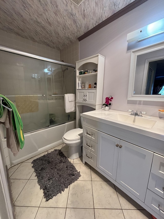 full bathroom with tile patterned floors, vanity, toilet, and shower / bath combination with glass door