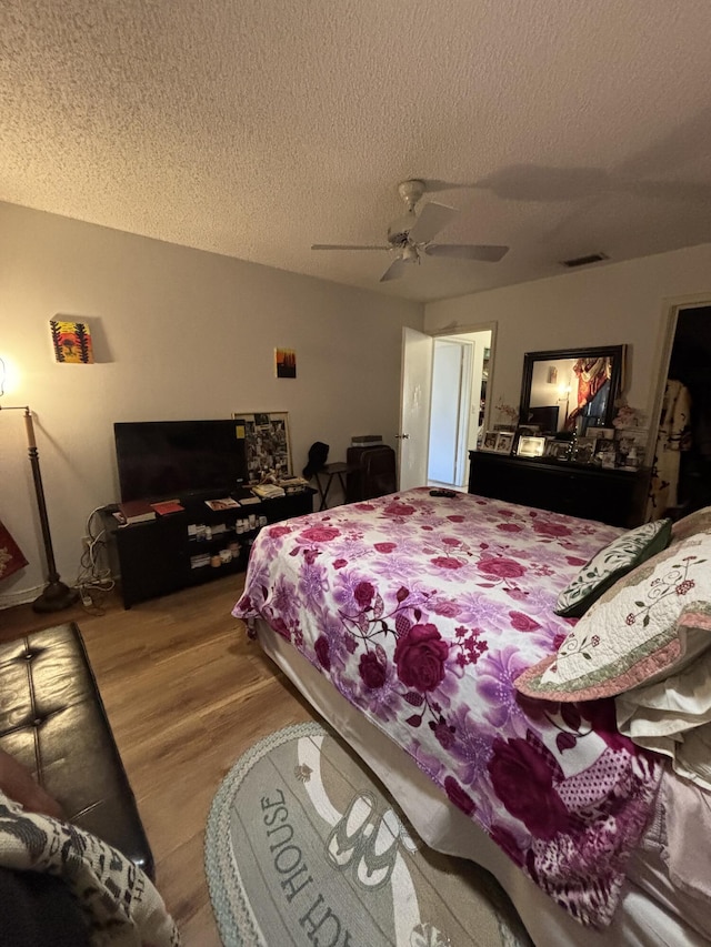 bedroom featuring ceiling fan, a textured ceiling, and hardwood / wood-style flooring