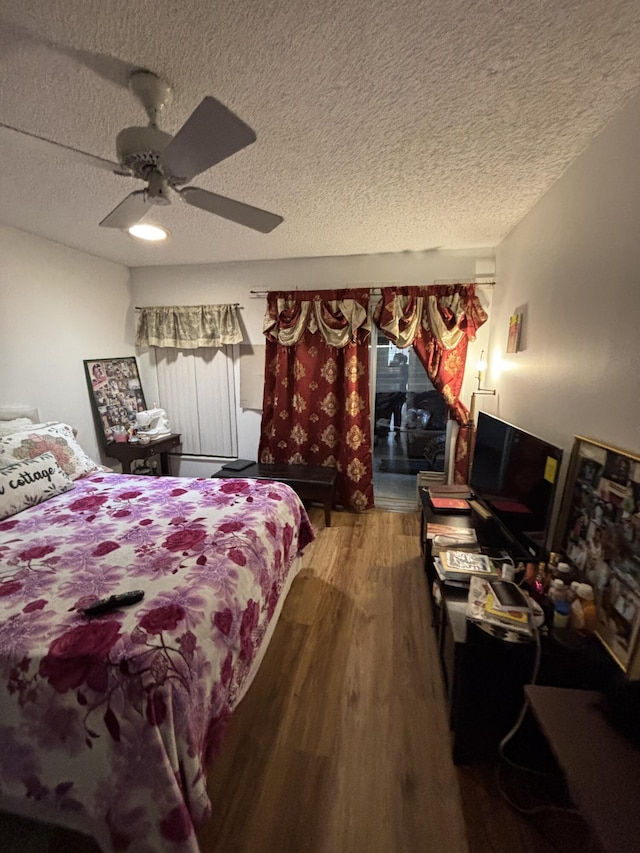 bedroom featuring hardwood / wood-style floors, a textured ceiling, and ceiling fan