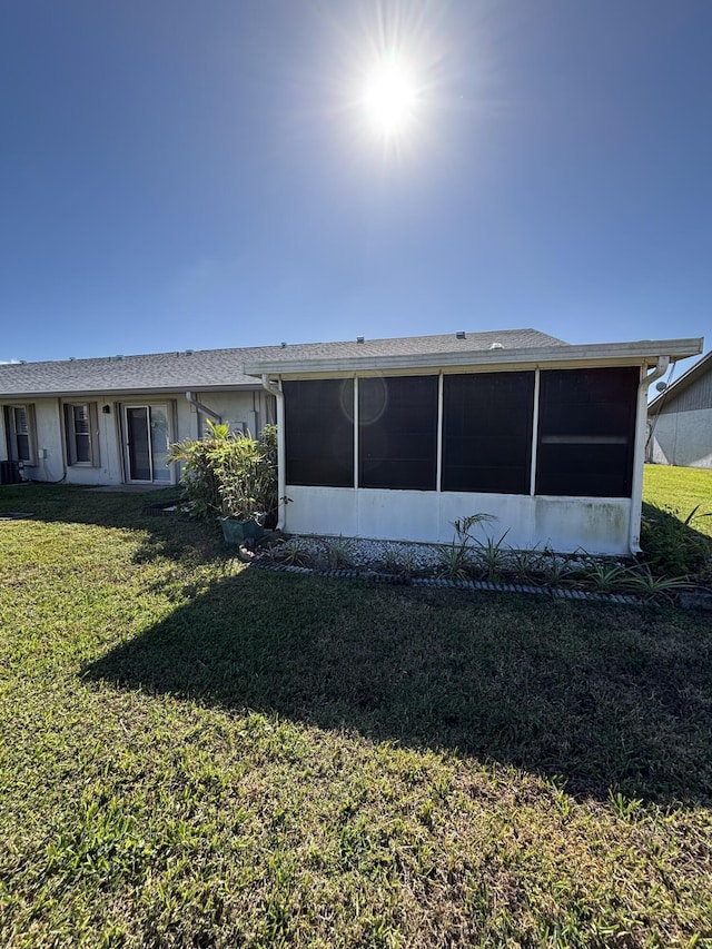 back of house with a sunroom and a yard