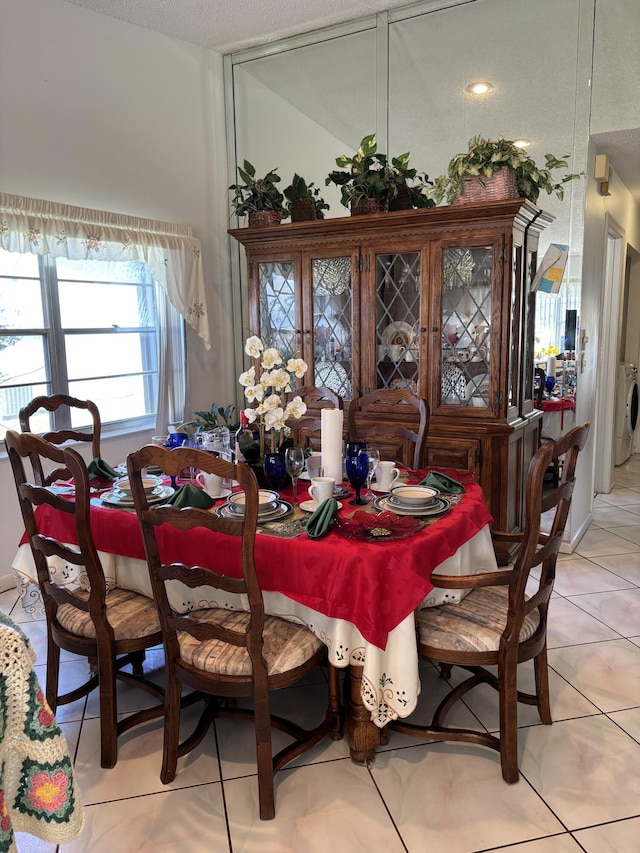 dining room featuring light tile patterned floors and washing machine and dryer