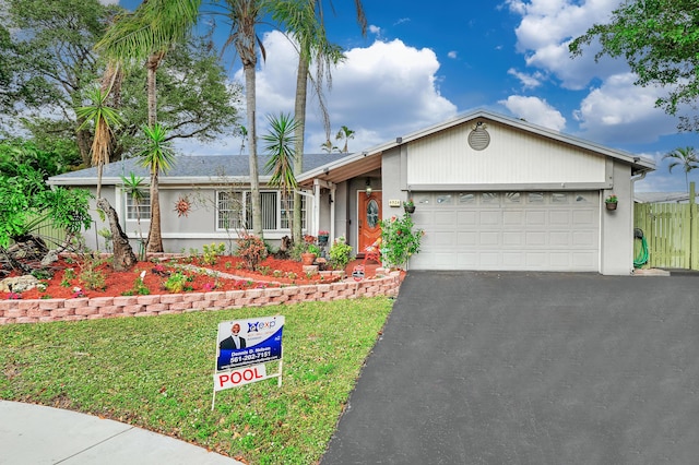 single story home featuring a garage and a front yard