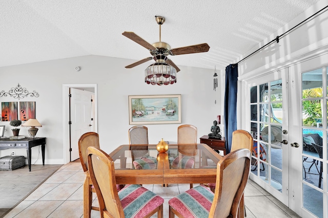 tiled dining room featuring lofted ceiling, ceiling fan, and a textured ceiling