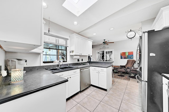 kitchen with light tile patterned flooring, appliances with stainless steel finishes, sink, white cabinets, and kitchen peninsula