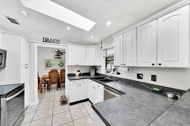 kitchen with light tile patterned flooring, sink, white cabinets, kitchen peninsula, and stainless steel appliances