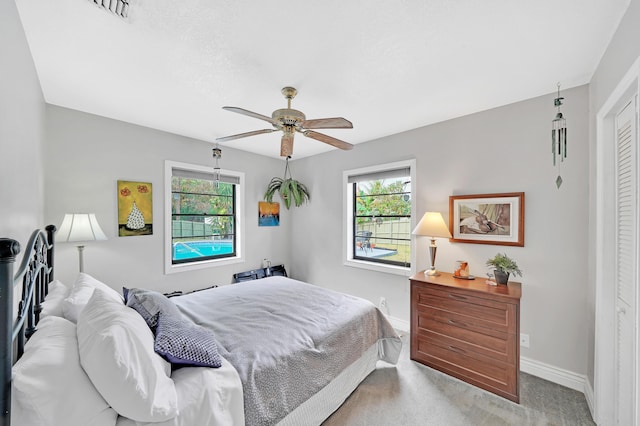 bedroom with ceiling fan, a closet, and light carpet