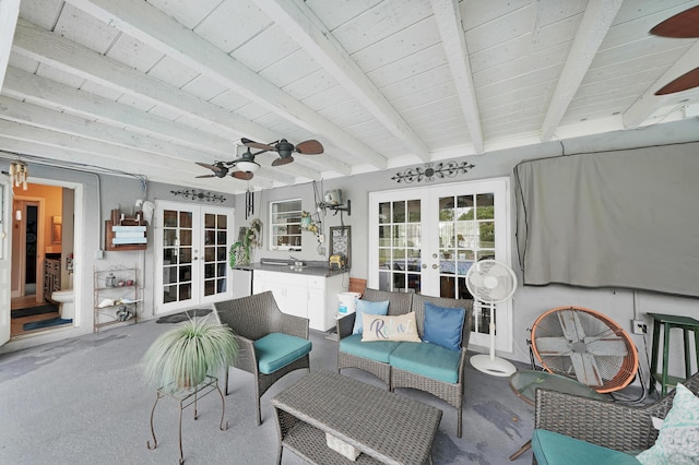 sunroom featuring ceiling fan, wood ceiling, beam ceiling, and french doors