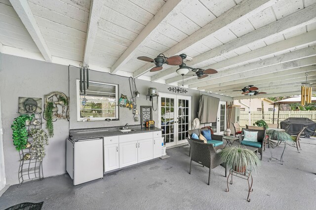 sunroom with french doors, ceiling fan, wood ceiling, and beamed ceiling