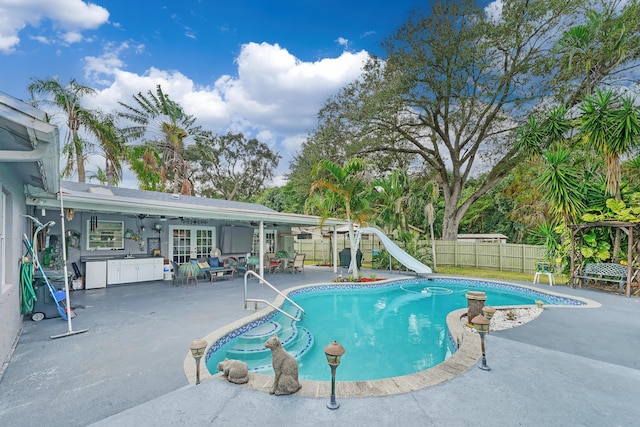 view of swimming pool featuring a patio, french doors, and a water slide