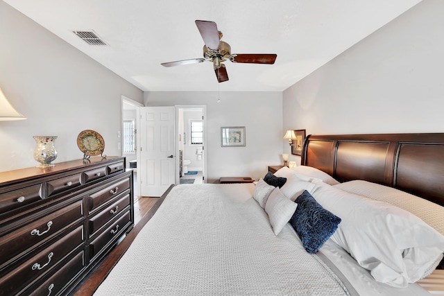 bedroom featuring ceiling fan, connected bathroom, and dark hardwood / wood-style flooring