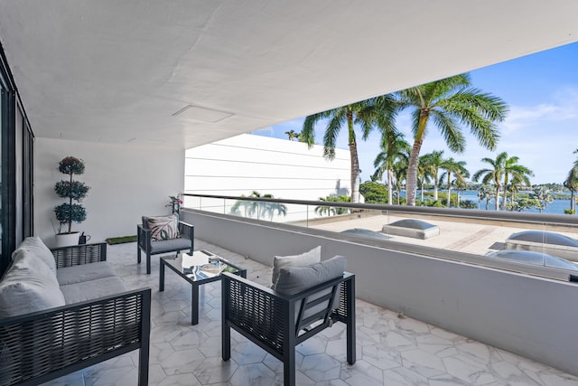 balcony with an outdoor living space and a water view