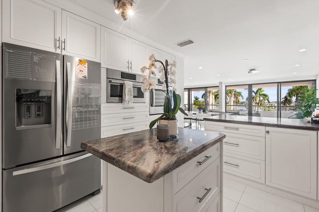 kitchen featuring white cabinetry, a kitchen island, stainless steel appliances, and light tile patterned floors