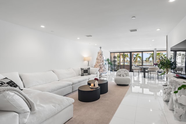 tiled living room featuring french doors and a wall of windows