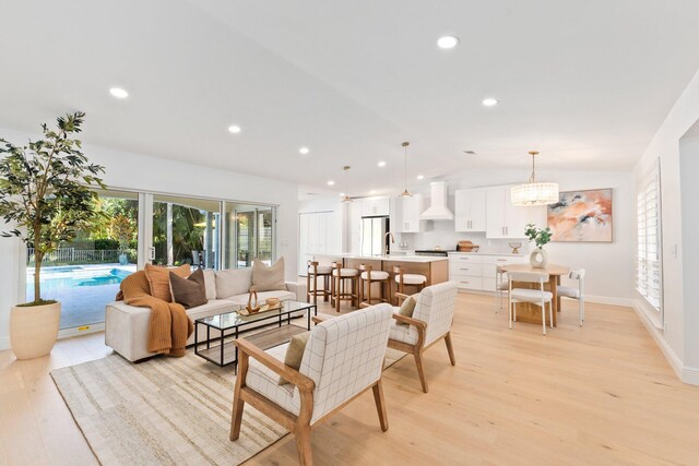 kitchen with custom range hood, stainless steel appliances, a spacious island, pendant lighting, and white cabinetry