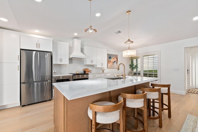 kitchen featuring appliances with stainless steel finishes, sink, custom exhaust hood, and a center island with sink