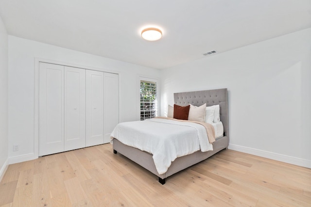 bedroom with light hardwood / wood-style floors and a closet