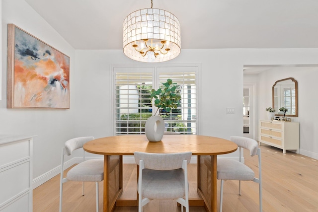 dining space with a notable chandelier and light hardwood / wood-style floors