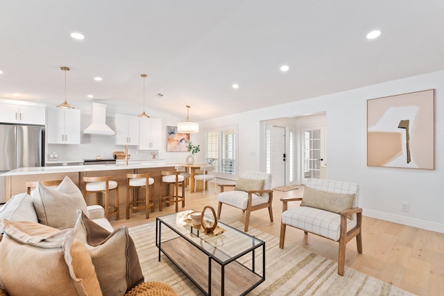 living room with lofted ceiling and light hardwood / wood-style flooring