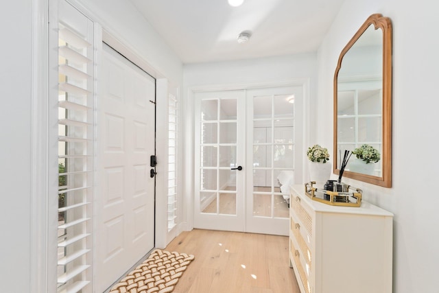 foyer with french doors and light hardwood / wood-style floors