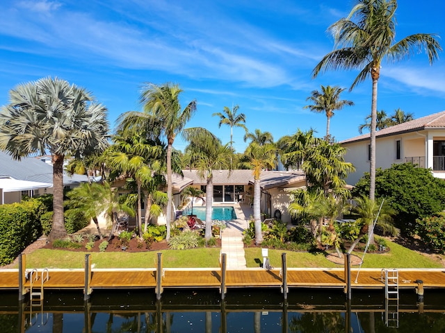 back of property with a yard, a patio, and a water view