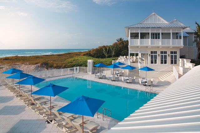 view of pool featuring a patio area and a water view