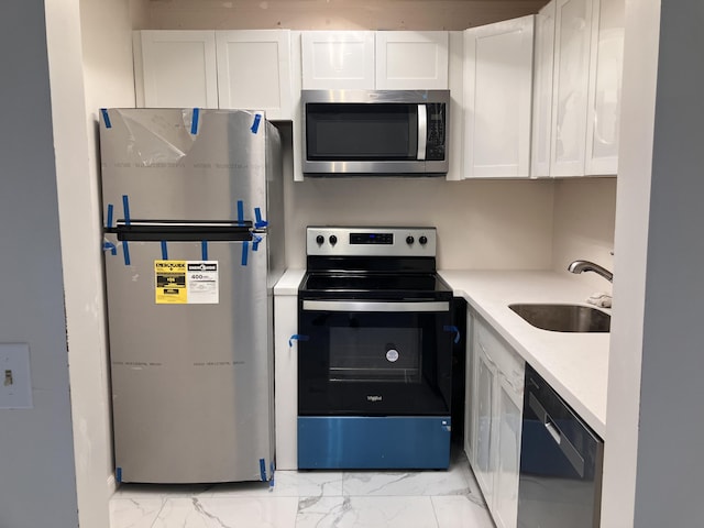 kitchen featuring white cabinets, appliances with stainless steel finishes, and sink