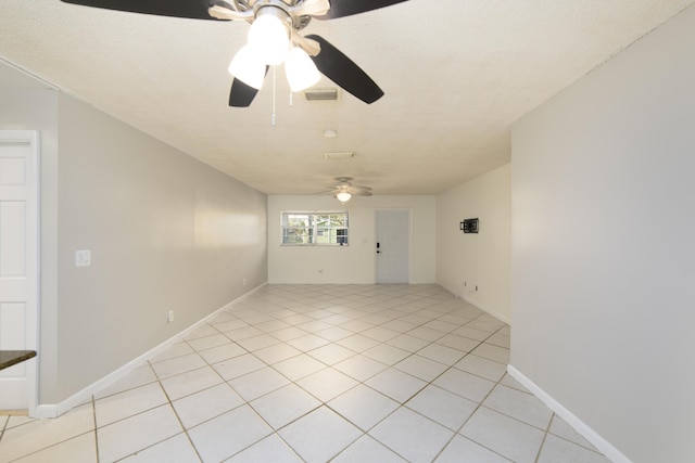 empty room with ceiling fan and light tile patterned floors