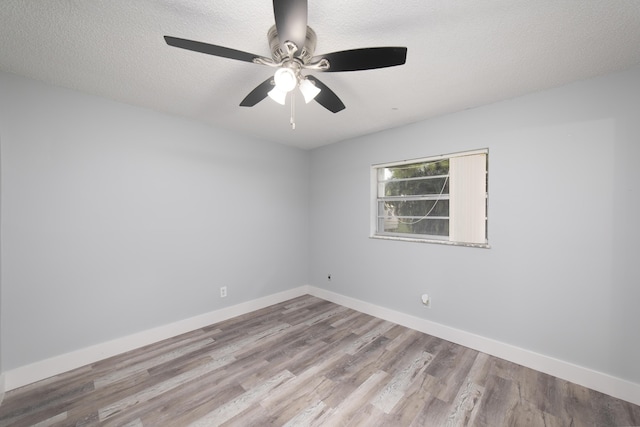 empty room with ceiling fan, light hardwood / wood-style floors, and a textured ceiling