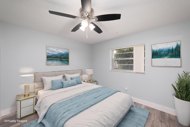 bedroom with a textured ceiling, light wood-type flooring, and ceiling fan