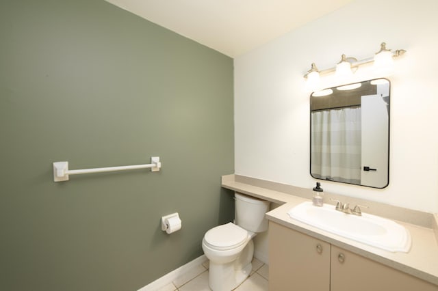 bathroom with toilet, vanity, and tile patterned floors