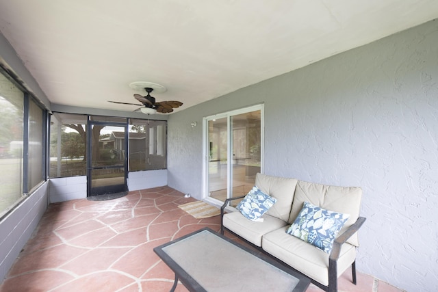 unfurnished sunroom with ceiling fan