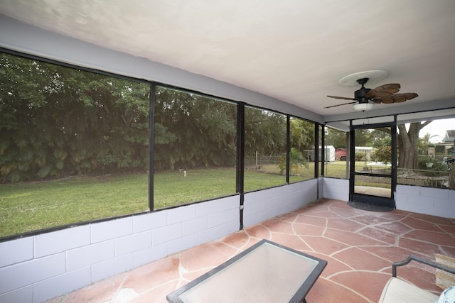 unfurnished sunroom featuring ceiling fan