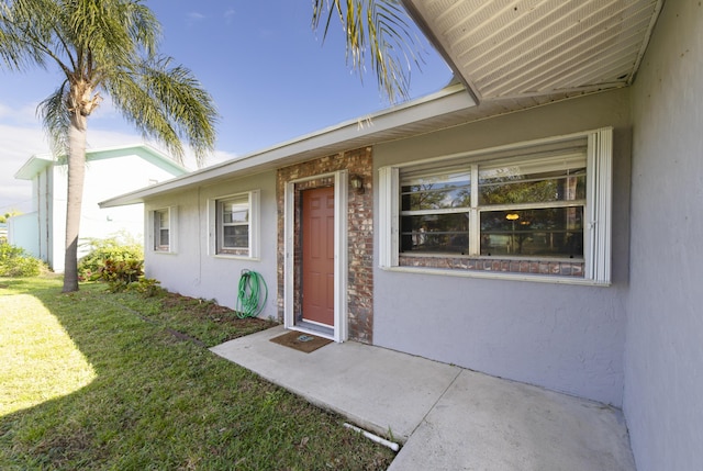 doorway to property featuring a yard