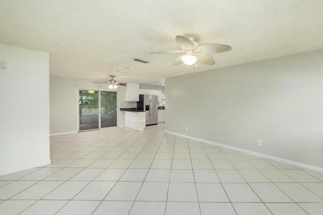 unfurnished living room with light tile patterned floors and a textured ceiling